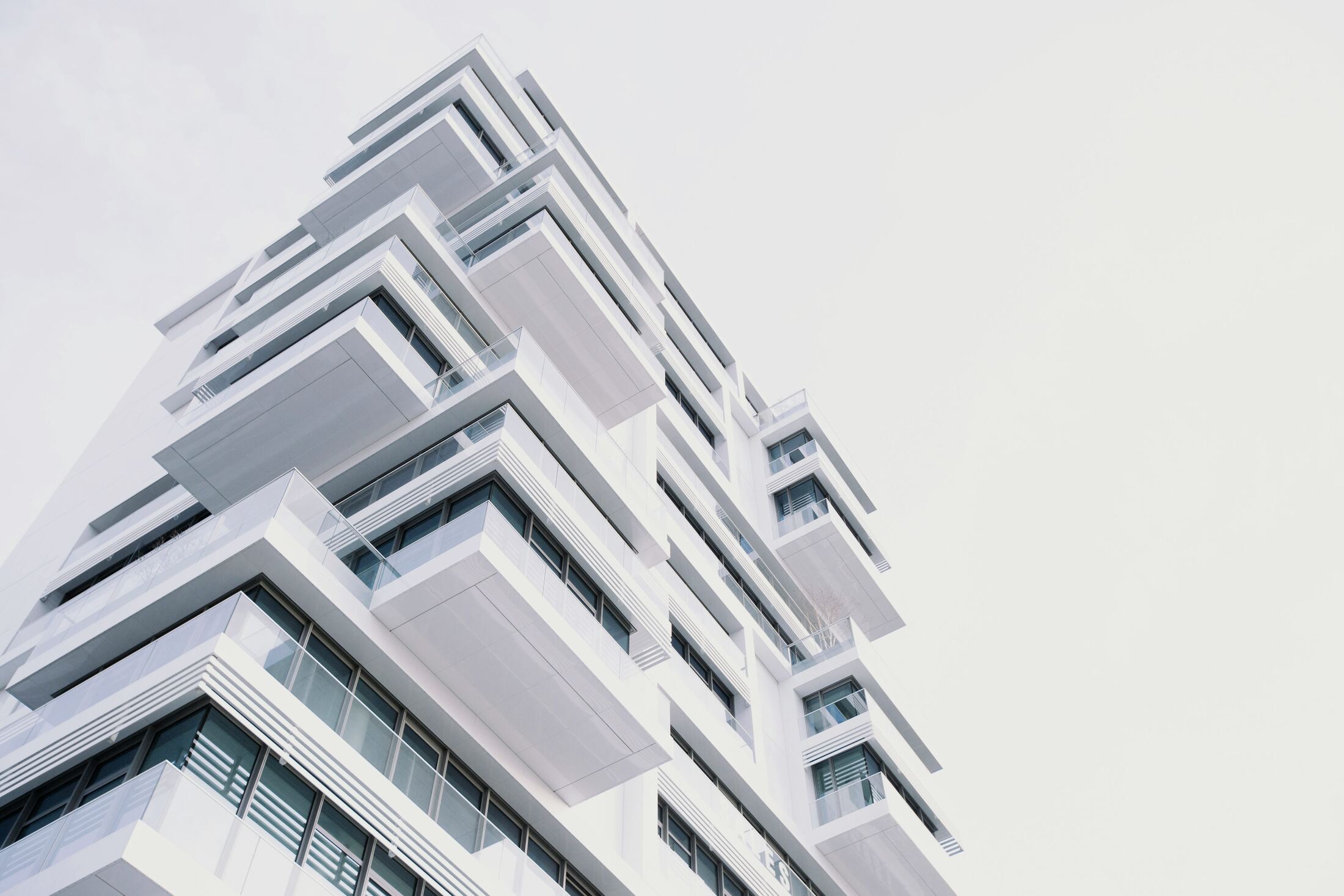 High-key architectural upshot of a white residential tower